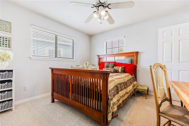 carpeted bedroom featuring ceiling fan, multiple windows, and baseboards