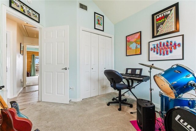 office space with vaulted ceiling, visible vents, carpet, and attic access