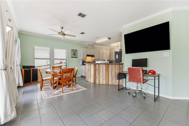 tiled dining room with baseboards, visible vents, ceiling fan, and crown molding