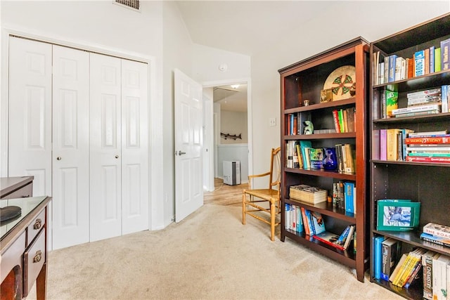 living area featuring attic access, carpet flooring, and visible vents