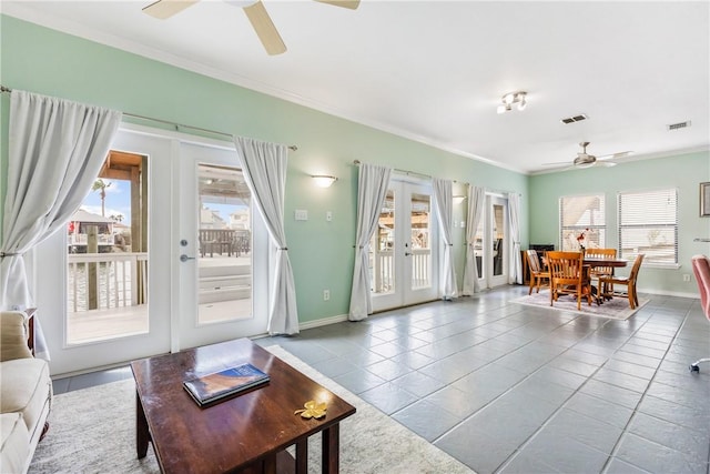 tiled living room featuring french doors, visible vents, ornamental molding, ceiling fan, and baseboards