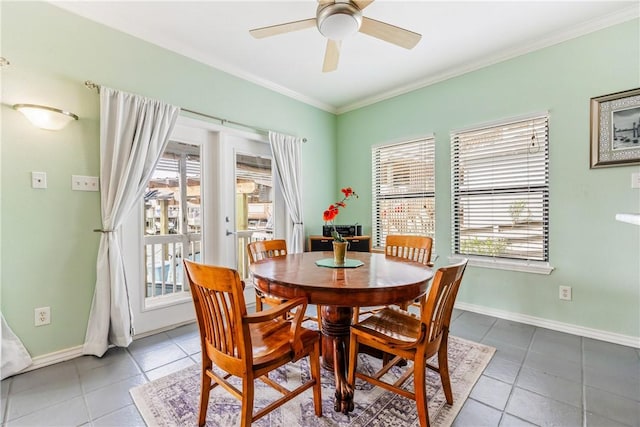 dining area with baseboards, ornamental molding, a ceiling fan, and tile patterned floors