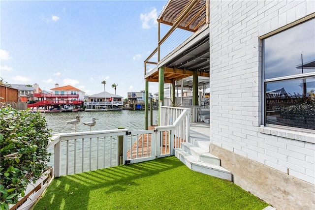 exterior space with a water view and a lawn