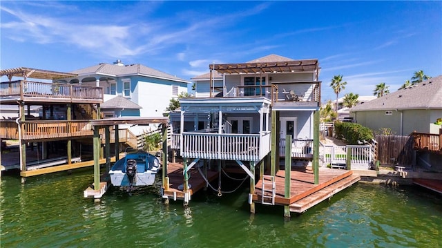 back of property with a deck with water view, boat lift, and a pergola