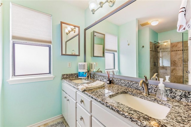 full bath with plenty of natural light, tiled shower, and a sink