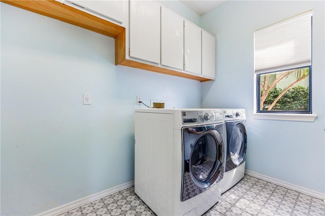 clothes washing area featuring light floors, baseboards, washer and clothes dryer, and cabinet space