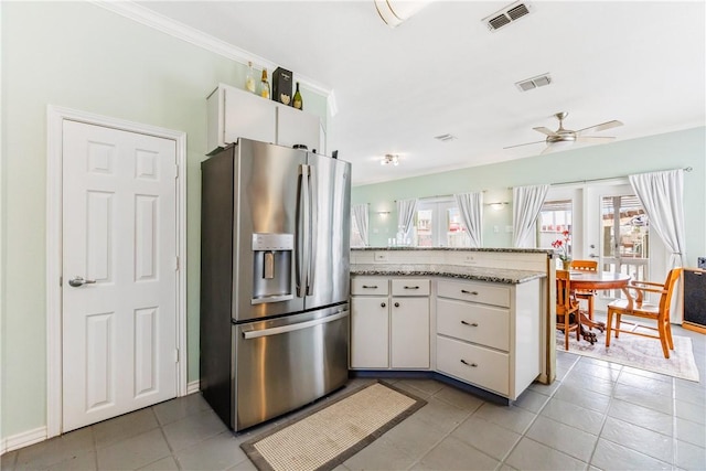 kitchen with visible vents, a peninsula, stainless steel fridge with ice dispenser, and white cabinetry