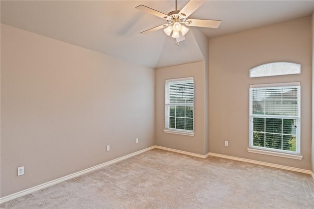 empty room with lofted ceiling, light colored carpet, ceiling fan, and a wealth of natural light