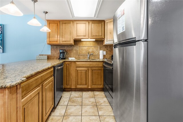 kitchen with stainless steel appliances, light stone counters, sink, backsplash, and pendant lighting