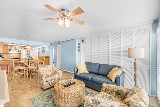 tiled living room with ceiling fan