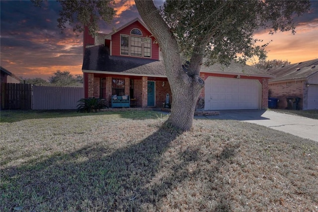 view of front of property with a lawn, covered porch, and a garage