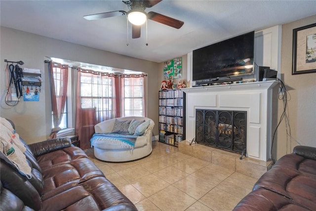 tiled living room with ceiling fan and a tiled fireplace