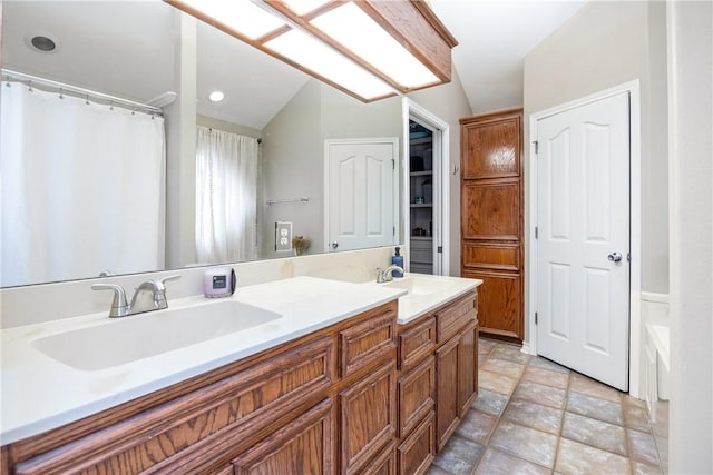 bathroom with lofted ceiling, double vanity, a sink, and a shower with curtain