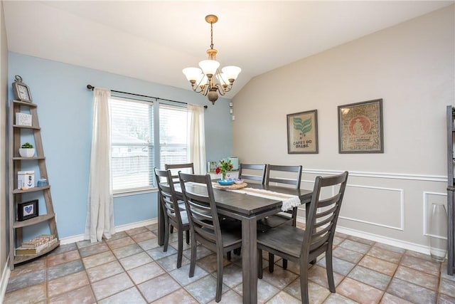 dining room featuring a chandelier, lofted ceiling, a wainscoted wall, and baseboards