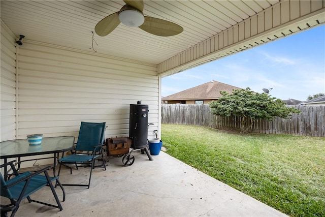 view of patio with outdoor dining space, fence, and ceiling fan