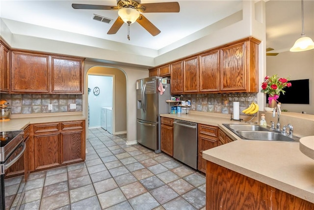 kitchen featuring light countertops, visible vents, hanging light fixtures, appliances with stainless steel finishes, and a sink