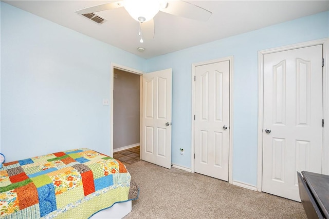 carpeted bedroom featuring visible vents, ceiling fan, and baseboards