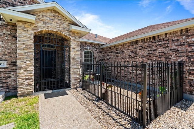 3902 Elvis Dr, Corpus Christi, TX 78414 - property entrance with a gate, fence, brick siding, stone siding, and roof with shingles