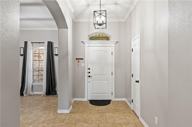 3902 Elvis Dr, Corpus Christi, TX 78414 - foyer with light tile patterned flooring, crown molding, arched walkways, baseboards, and a chandelier