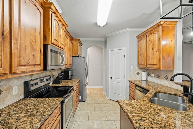3902 Elvis Dr, Corpus Christi, TX 78414 - kitchen with appliances with stainless steel finishes, arched walkways, a sink, dark stone countertops, and ornamental molding