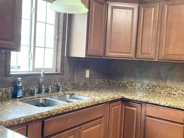kitchen with tasteful backsplash, sink, and stone countertops