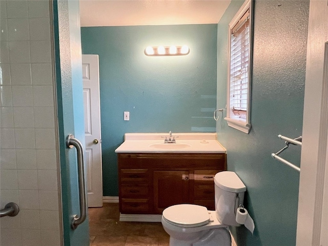 bathroom with toilet, vanity, and tile patterned floors