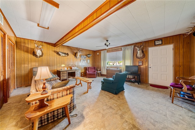 living room featuring wooden walls and ceiling fan