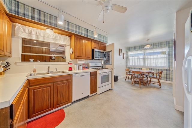 kitchen with sink, ceiling fan, white appliances, light colored carpet, and pendant lighting