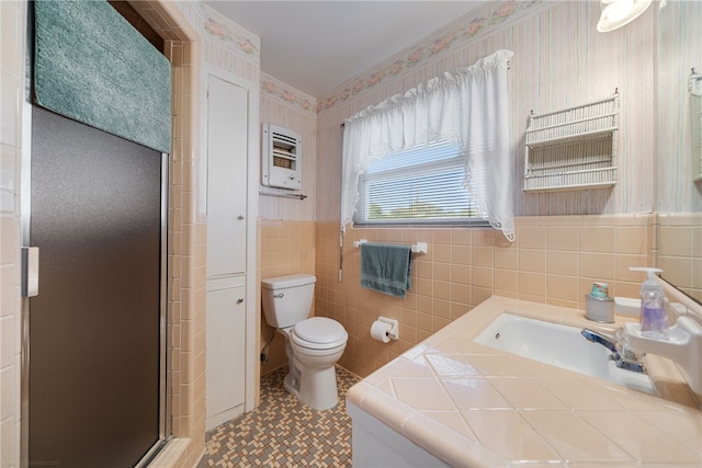 bathroom with tile walls, vanity, an enclosed shower, and toilet