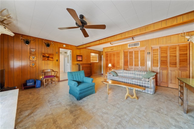 living room with ceiling fan and wooden walls