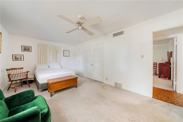 carpeted bedroom featuring ceiling fan and a closet