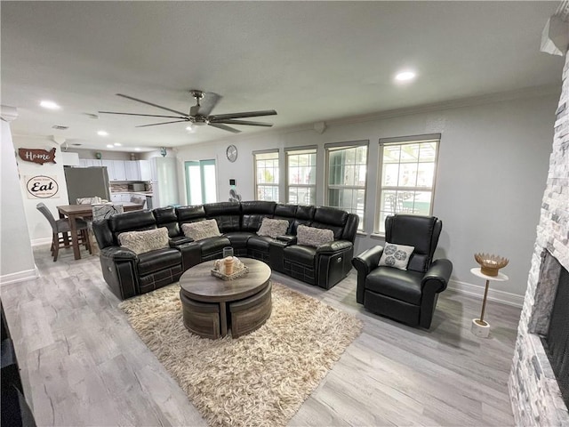15321 Beaufort Ct, Corpus Christi, TX 78418 - living room featuring ceiling fan, a stone fireplace, crown molding, light wood-style flooring, and recessed lighting