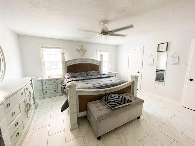 15321 Beaufort Ct, Corpus Christi, TX 78418 - bedroom featuring multiple windows, light marble finish floors, ceiling fan, and a textured ceiling