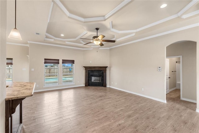 unfurnished living room with light wood-type flooring, crown molding, ceiling fan, and coffered ceiling