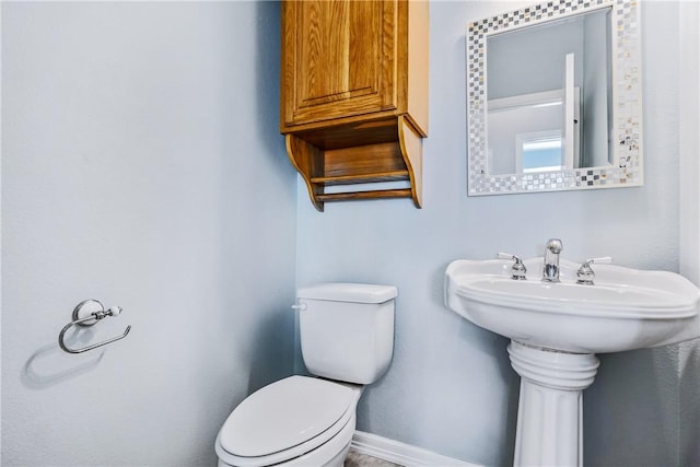 bathroom with toilet and baseboards