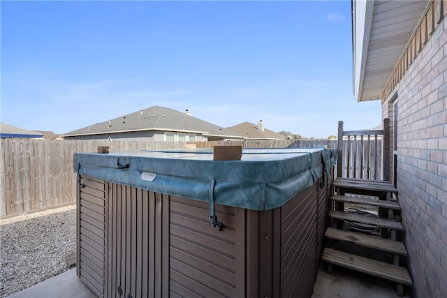 view of patio / terrace featuring a hot tub and fence