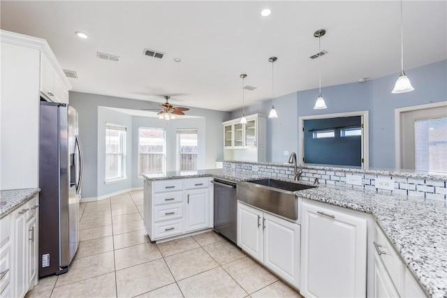 kitchen with a peninsula, white cabinetry, stainless steel appliances, and hanging light fixtures