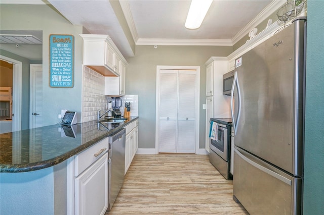 kitchen featuring tasteful backsplash, light wood-type flooring, crown molding, white cabinetry, and appliances with stainless steel finishes