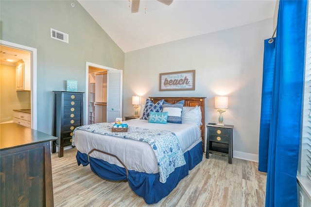 bedroom featuring ceiling fan, light wood-type flooring, connected bathroom, and high vaulted ceiling