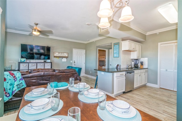 dining room featuring light hardwood / wood-style flooring, ceiling fan, crown molding, and sink