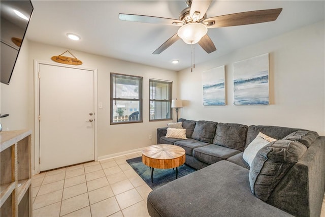 living area featuring baseboards, a ceiling fan, and light tile patterned floors
