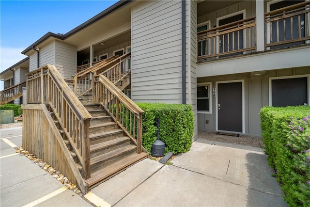 view of exterior entry featuring board and batten siding and a balcony