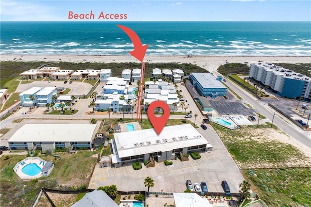 birds eye view of property with a water view and a beach view