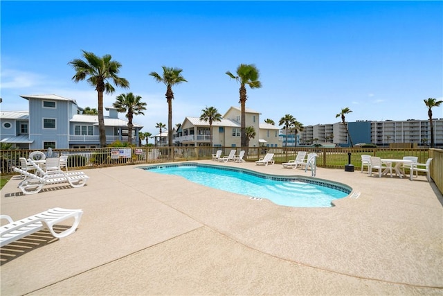 pool with a patio and fence