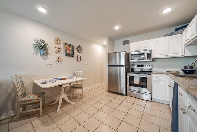 kitchen with light tile patterned flooring, white cabinetry, stainless steel appliances, and visible vents