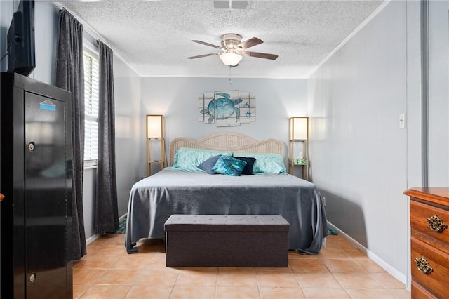 627 S Fuqua St, Rockport, TX 78382 - bedroom featuring crown molding, light tile patterned flooring, a textured ceiling, ceiling fan, and baseboards