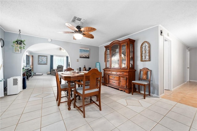 627 S Fuqua St, Rockport, TX 78382 - dining area with ornamental molding, a ceiling fan, light tile patterned floors, a textured ceiling, and arched walkways