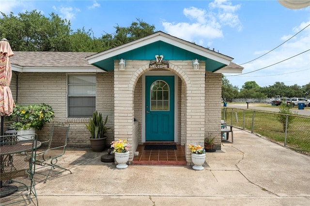 627 S Fuqua St, Rockport, TX 78382 - property entrance with brick siding and a shingled roof