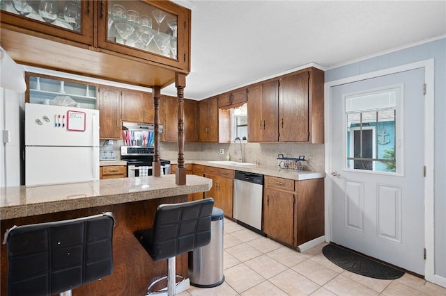 627 S Fuqua St, Rockport, TX 78382 - kitchen featuring stainless steel appliances, a sink, tasteful backsplash, light tile patterned floors, and crown molding