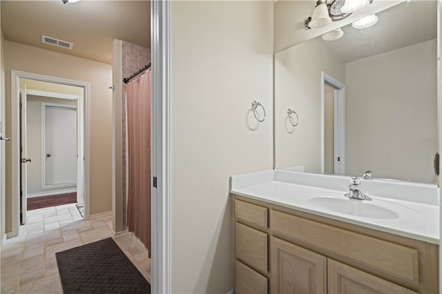 bathroom featuring walk in shower and vanity